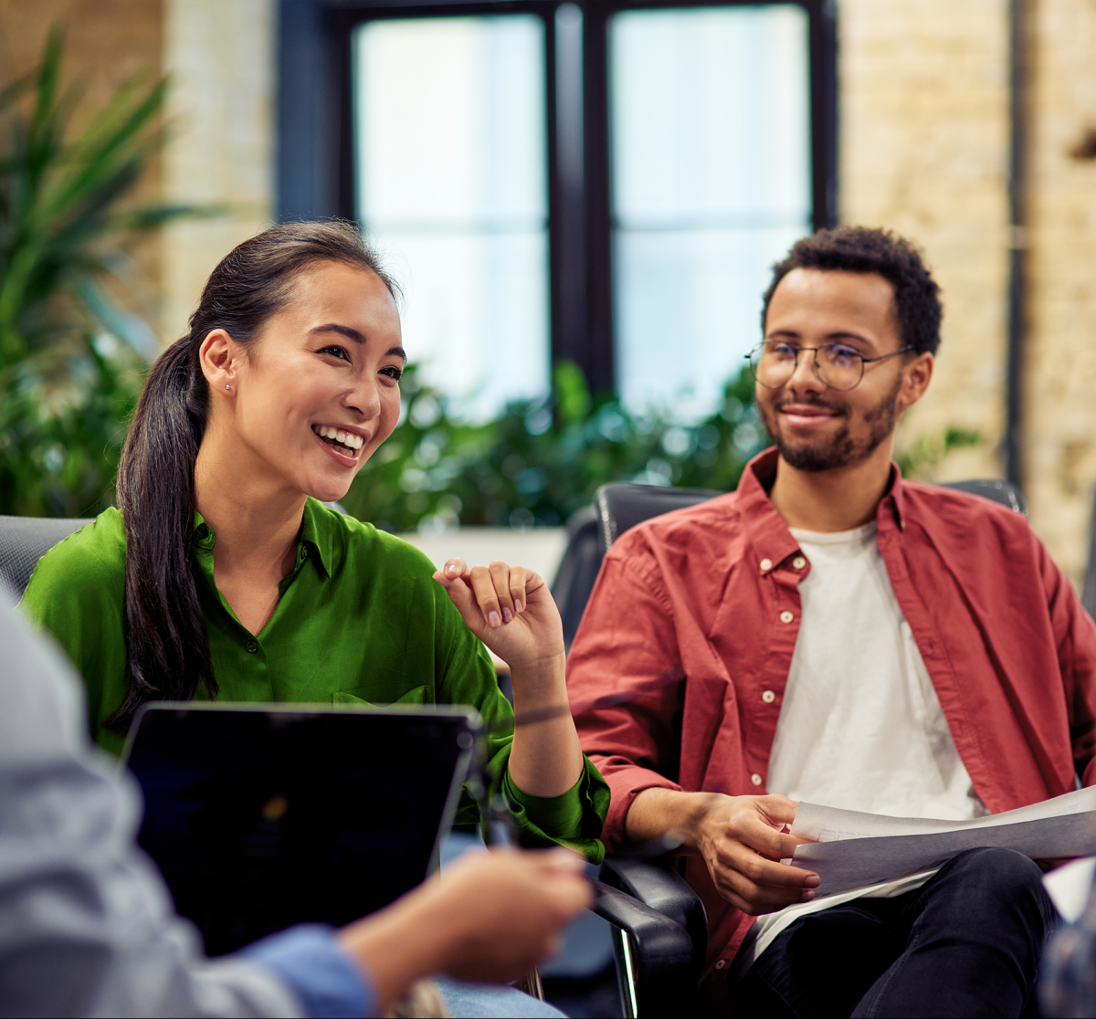 Zwei Personen im Gespräch während eines Meetings in einem modernen Büro.
